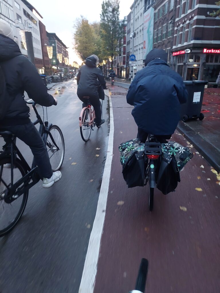 3 cyclists in the rain in Amsterdam