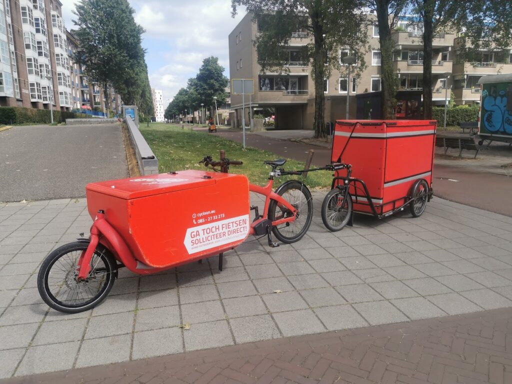 red cargo bike of a bicycle courier with electric assist technology